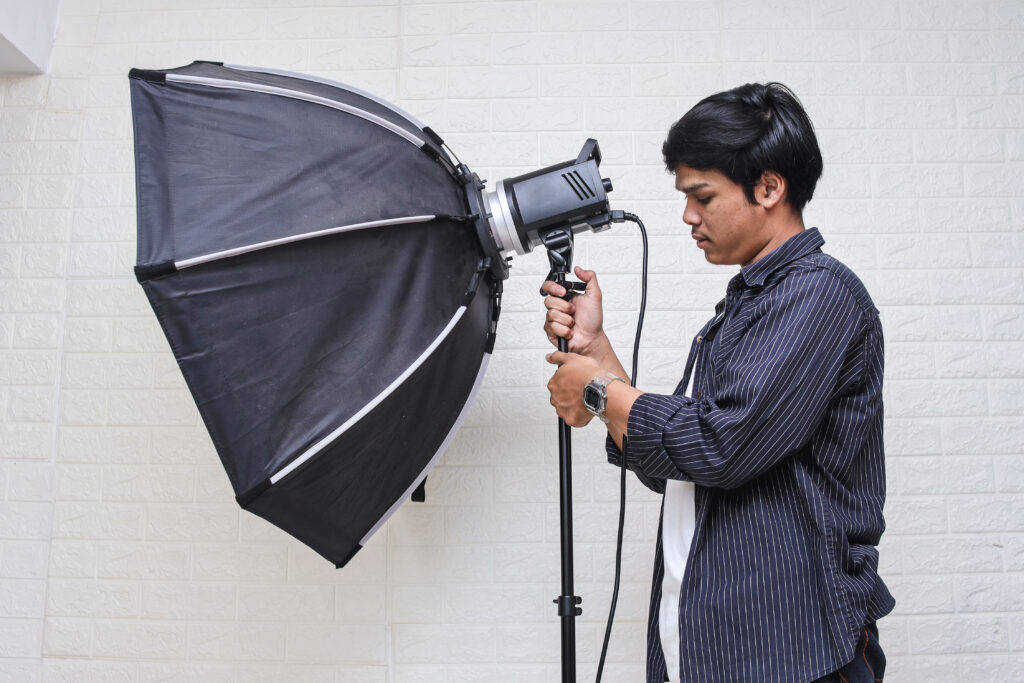 assistant wedding photographer capturing moments with a flash and light modifier