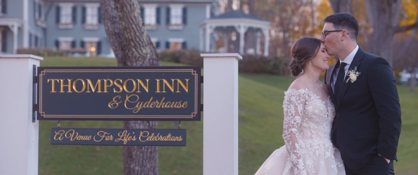 Humblebee Wedding The Thompson Inn, newlyweds embrace in front of the venue sign