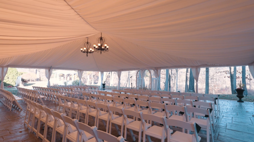 Humblebee Wedding Films The Riverview, ceremony tent with white chairs set up for guests