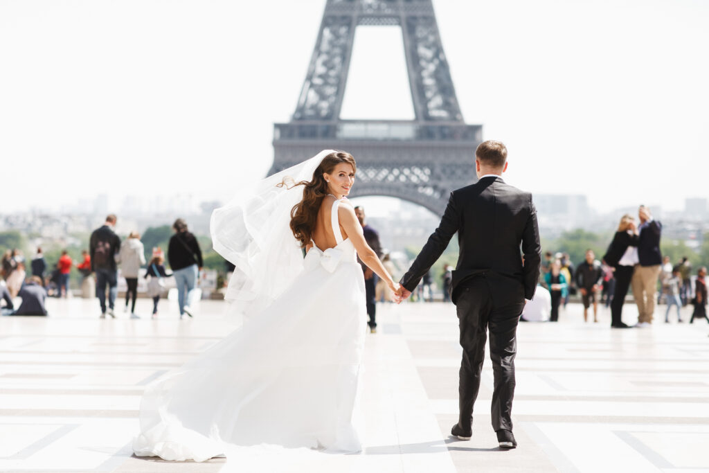Humblebee Wedding Films Destination Wedding Videographer, Beautiful wedding couple has fun posing on the square before the Eiffel Tower in Paris