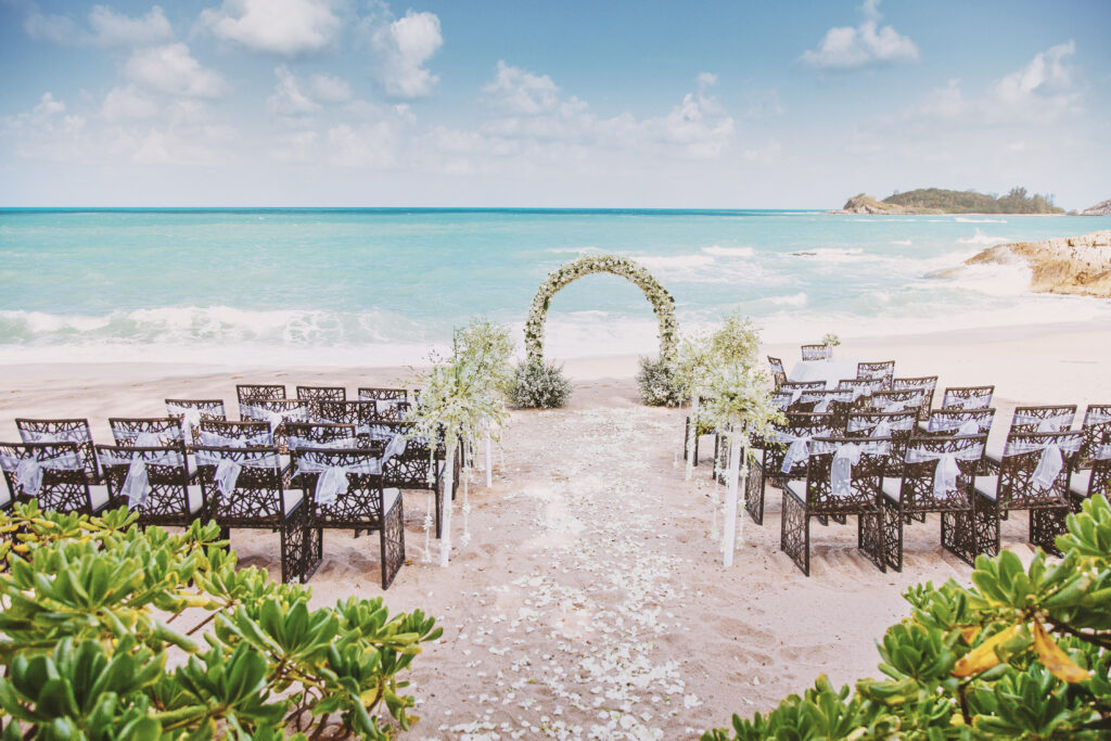 Humblebee Wedding Films Destination Wedding Videographer, Beautiful beach wedding venue setting with flowers, floral decoration on arch, panoramic ocean view