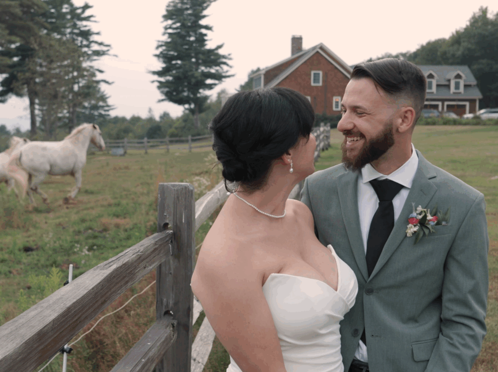 Humblebee Wedding Videography Cold Spring Farm, bride and groom smile and laugh as horses run in the background