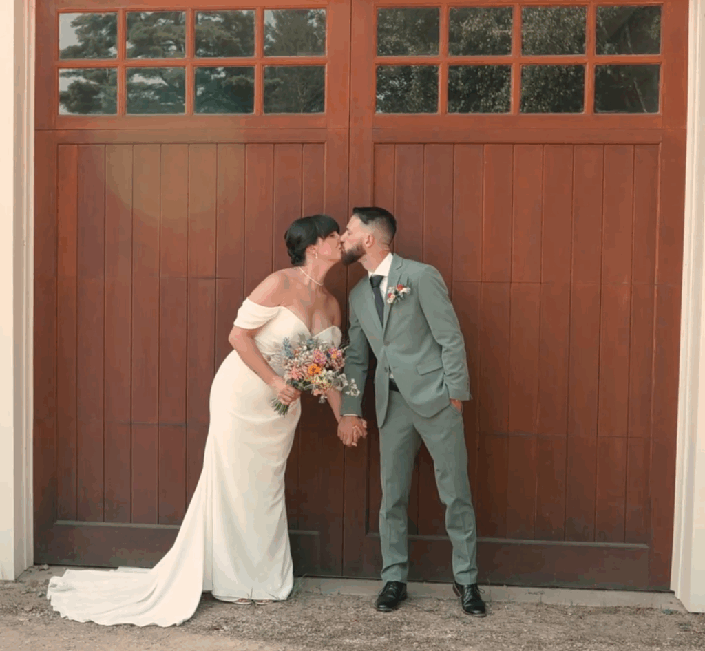 Humblebee Wedding Videography Cold Spring Farm, bride and groom share a kiss in front of a large barn door