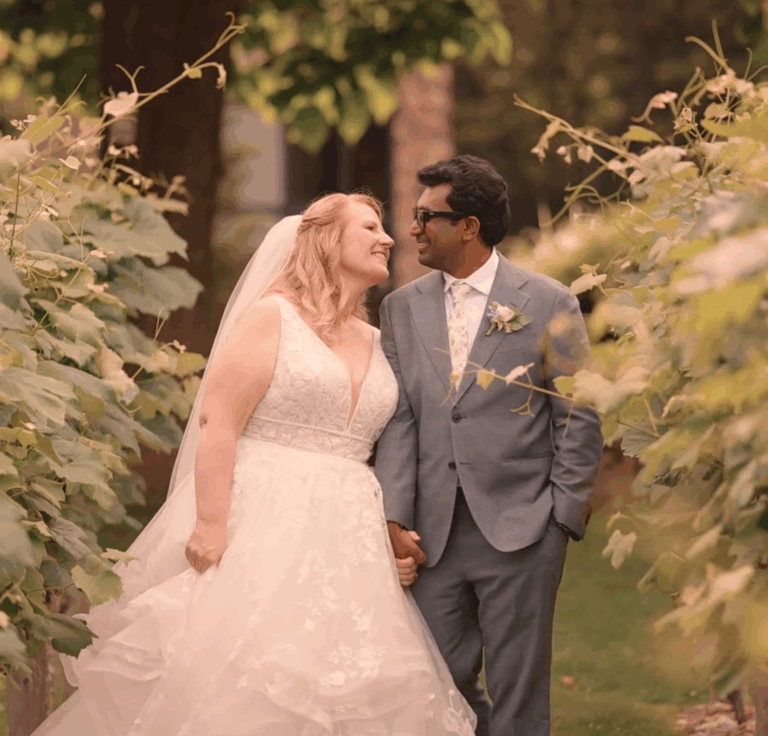 Humblebee Wedding Films Birch Wood Vineyards, newlyweds smile at each other as they pose for photos among vineyards