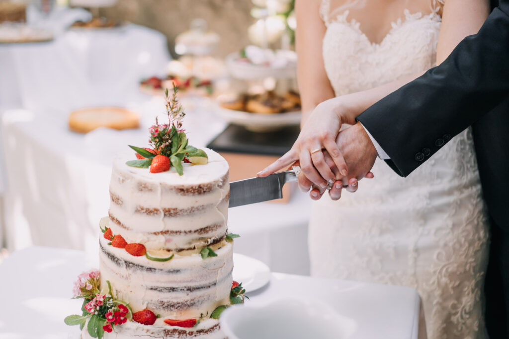 Humblebee Wedding Films Wedding Photography Styles, a bride and a groom cutting a strawberry wedding cake