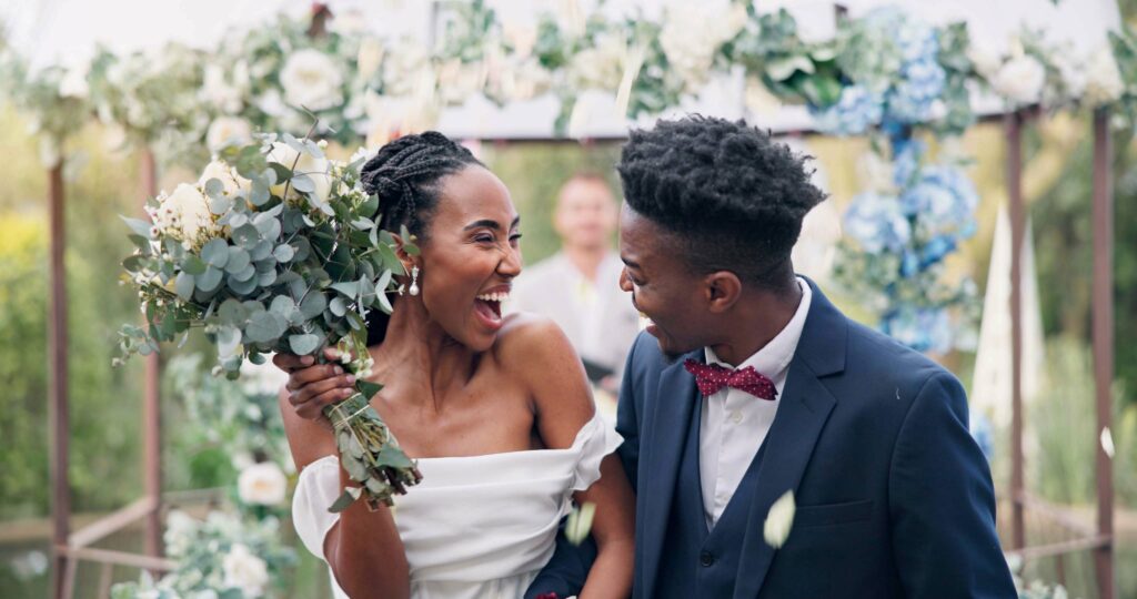 Humblebee Wedding Films Wedding Photography Styles, Couple, flower confetti and outdoor wedding with event, walk and happy laugh in nature. Black woman, man and excited for marriage, floral bouquet or holding hands in park, party or together in aisle.