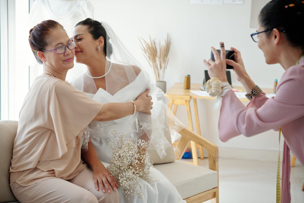 Humblebee Wedding Films Boston wedding content creator, Bride kissing her mother of cheek when tailor photographing them for social media