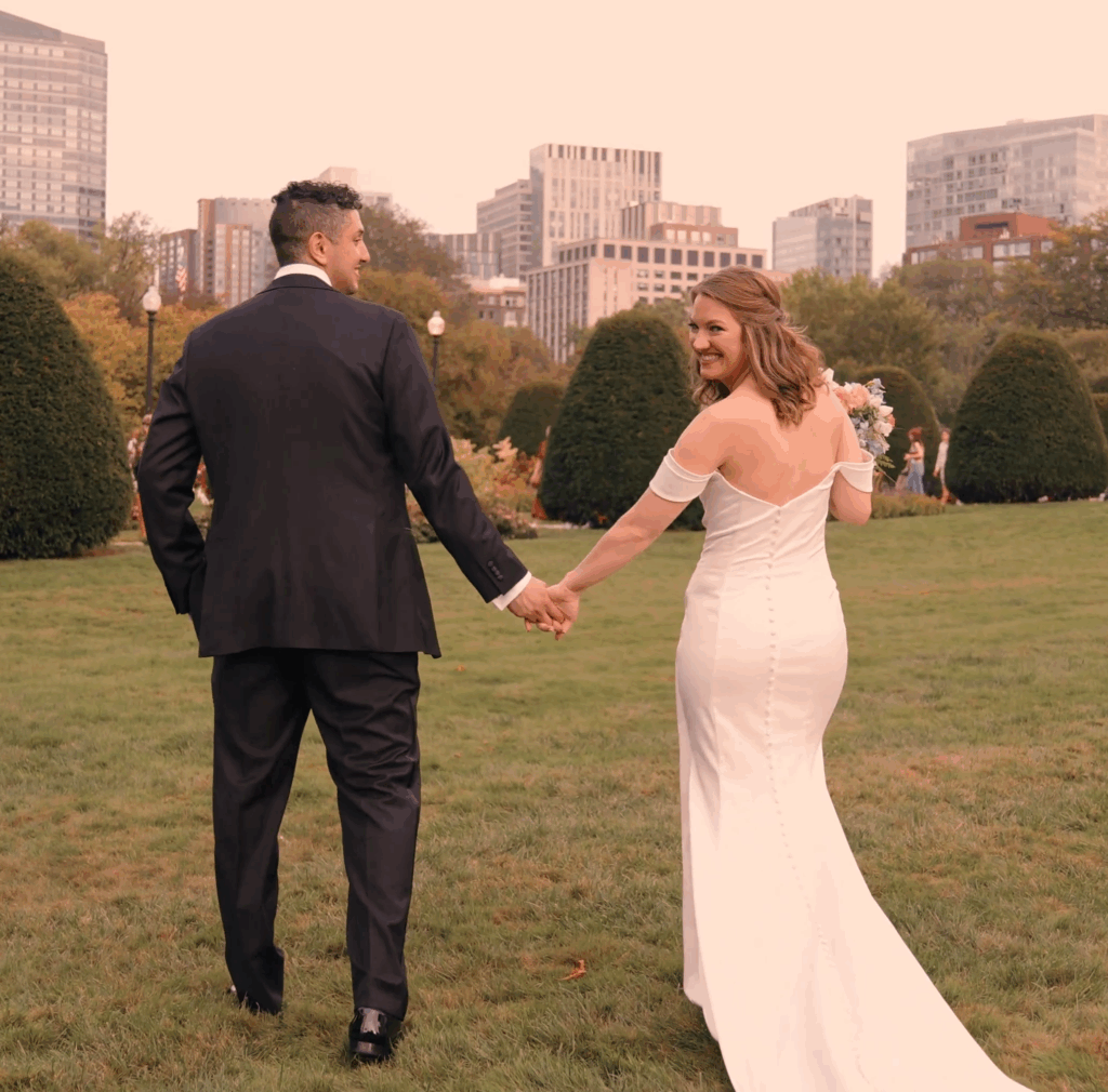 Humblebee Wedding Films Boston Public Library, newlyweds walk away from camera, bride looking over shoulder, at Boston Commons