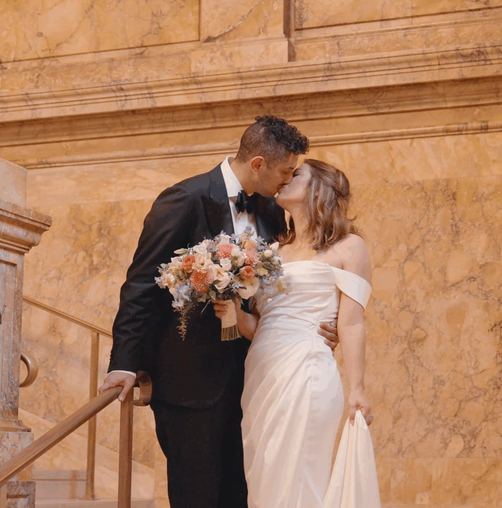 Humblebee Wedding Films Boston Public Library, newlyweds share a kiss in a marble stairway