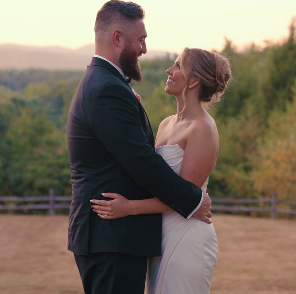 Humblebee Wedding Films Questions To Ask Wedding Videographer Questions To Ask Photographer & Videographer Newlyweds embrace with wooded scenery behind them