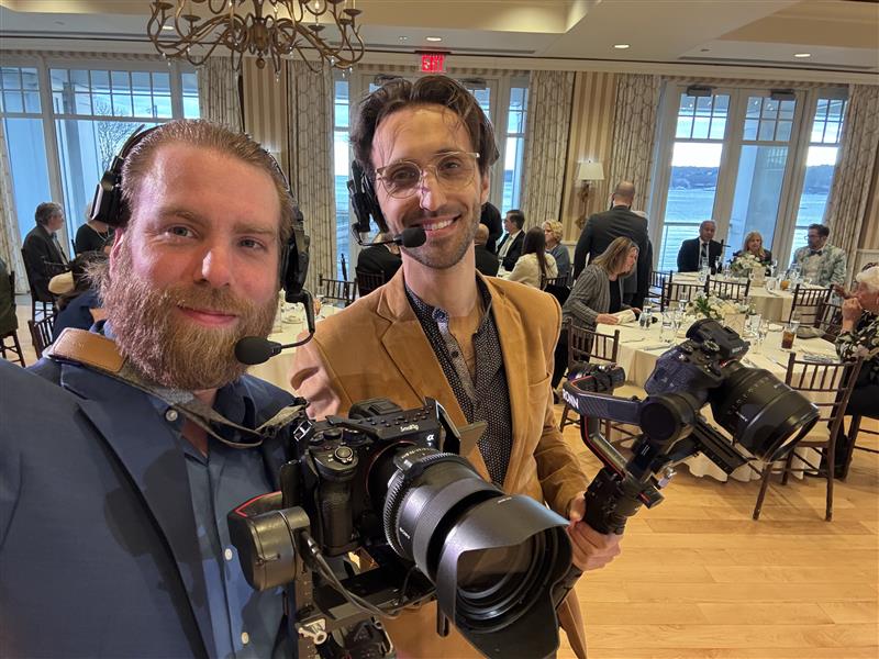 Surprising Fees for Wedding Videographers Near Me 5 Two male wedding videographers pose for a behind the scenes picture at a wedding ceremony